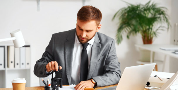man in the office stamping documents